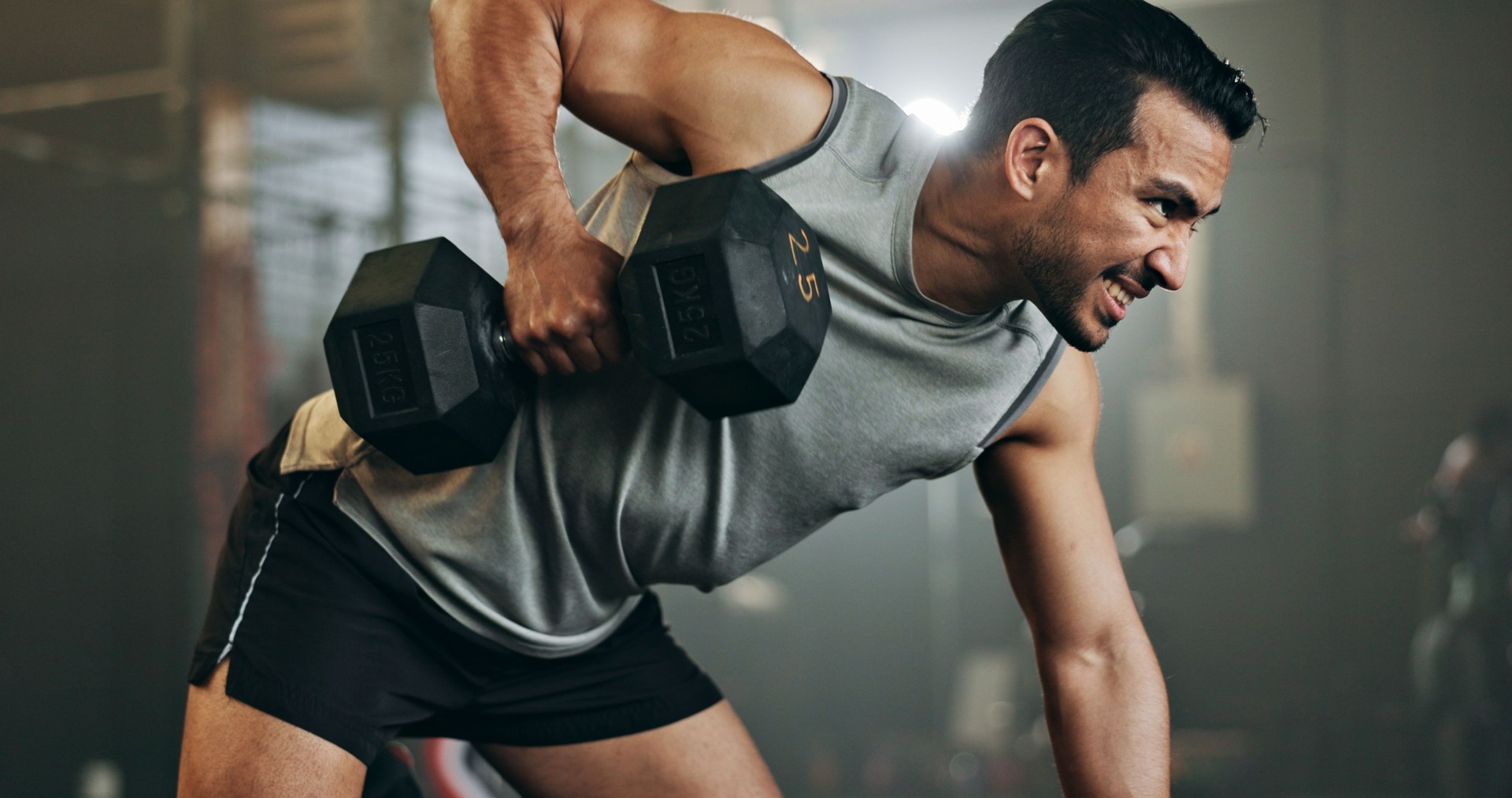 Man, dumbbell and weightlifting in fitness, workout or arm exercise on bench at indoor gym. Serious male person, bodybuilder or athlete lifting weight in sports training, health and wellness at club